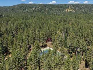 Nestled amidst a dense forest, this property offers a private retreat with a charming cabin and a dedicated tennis court.