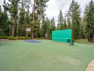 Enjoy outdoor recreation with this versatile sports court, featuring a basketball hoop and a handball wall, perfect for active families.