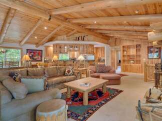 Experience rustic charm in this spacious living area, featuring a large sectional sofa perfect for gatherings and a beautiful wooden coffee table.
