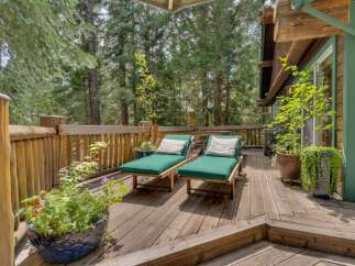 Relax and unwind on this charming wooden deck, nestled amidst a serene forest setting.