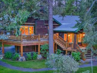Experience rustic charm and modern comfort in this stunning log cabin home, nestled amidst lush greenery.