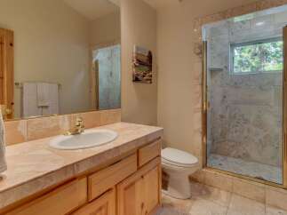This bathroom features a spacious vanity with a marble countertop and a large sink, perfect for morning routines.