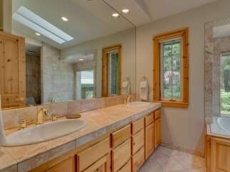 This luxurious bathroom features a double vanity with elegant gold fixtures and a spacious countertop, perfect for a spa-like experience.