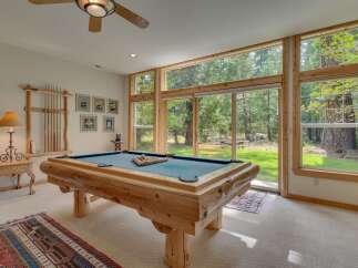 Experience ultimate relaxation and entertainment in this stunning game room, featuring a rustic log-style pool table perfect for friendly competitions.