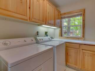 This laundry room features a Whirlpool electronic dryer and a Supreme washing machine, perfect for handling your household chores.