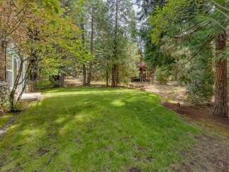Enjoy the serene outdoor living space of this property, featuring a lush green lawn perfect for recreation and relaxation.