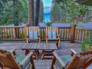 Enjoy breathtaking lake views from this charming log cabin's expansive deck, perfect for relaxing or entertaining.