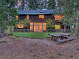 Nestled amongst tall trees, this charming wooden home offers a rustic retreat.