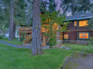 Nestled amongst towering trees, this charming log cabin offers a serene retreat with its rustic architecture and inviting ambiance.