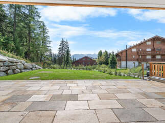 Experience breathtaking mountain views from this stunning property, featuring a spacious stone patio perfect for outdoor entertaining.