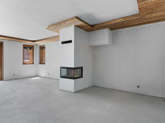 Experience modern living in this unfinished interior space, featuring a striking corner fireplace with a glass enclosure and a sleek, minimalist design.