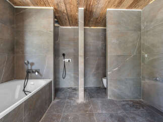 Experience modern luxury in this spacious bathroom featuring a deep soaking tub and a separate walk-in shower.