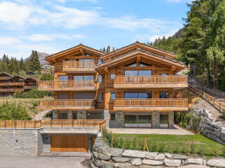 Experience luxury mountain living in this stunning multi-story wooden chalet, nestled amidst a serene forest landscape.