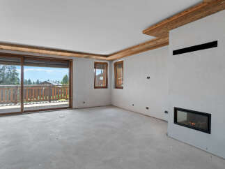Experience modern mountain living in this spacious room featuring a sleek gas fireplace and expansive sliding glass doors that open to a private balcony with stunning views.