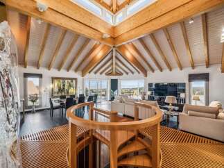 Experience luxurious living in this stunning open-concept home featuring a soaring vaulted ceiling with exposed wooden beams and abundant natural light.