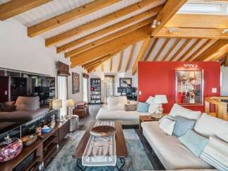 Experience luxurious living in this stunning home featuring a vaulted wood-beamed ceiling and a vibrant red accent wall that adds a dramatic flair.