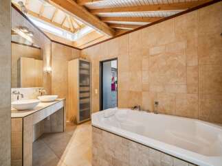 Experience luxury in this stunning bathroom featuring a deep soaking tub and a double vanity with vessel sinks.