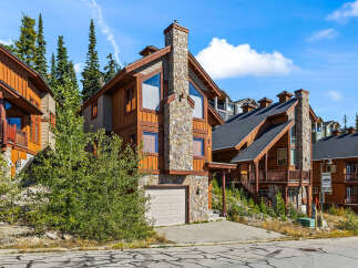 Experience mountain living in this stunning timber-frame home, featuring a grand stone chimney and expansive windows that capture breathtaking views.