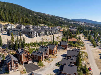 Discover this stunning mountain retreat featuring modern ski chalets nestled amidst a dense evergreen forest.