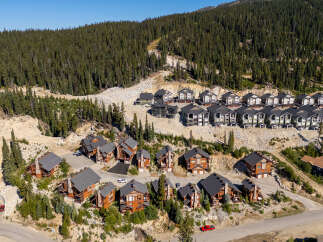 Discover luxury mountain living in this stunning collection of modern chalets nestled amidst a dense evergreen forest.