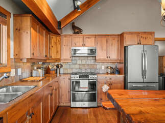 Discover this charming kitchen featuring warm wooden cabinetry and a rustic stone tile backsplash.