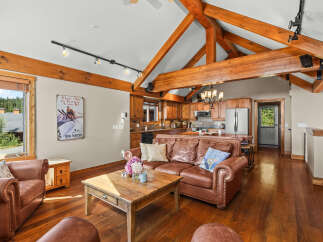 Experience rustic charm in this spacious living area featuring a plush leather sofa and a rustic wooden coffee table, perfect for cozy gatherings.