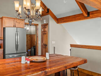 Experience rustic charm in this kitchen and dining area, featuring a large wooden table perfect for gatherings.