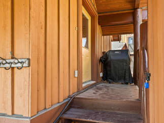 Enjoy outdoor living with this covered porch featuring a Weber grill, perfect for summer cookouts.