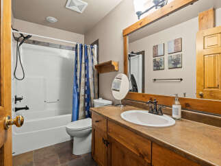 This bathroom features a clean white bathtub and toilet, complemented by a stylish blue and white patterned shower curtain.