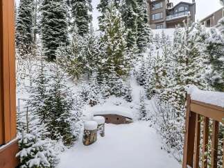 Experience the serene beauty of a winter wonderland with this stunning property nestled amongst snow-covered pine trees.