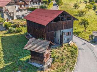 Discover this charming property featuring a rustic barn with a distinctive red roof, perfect for storage or conversion.