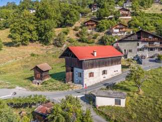 Discover this charming property nestled on a hillside, offering a unique blend of rustic and traditional architecture.