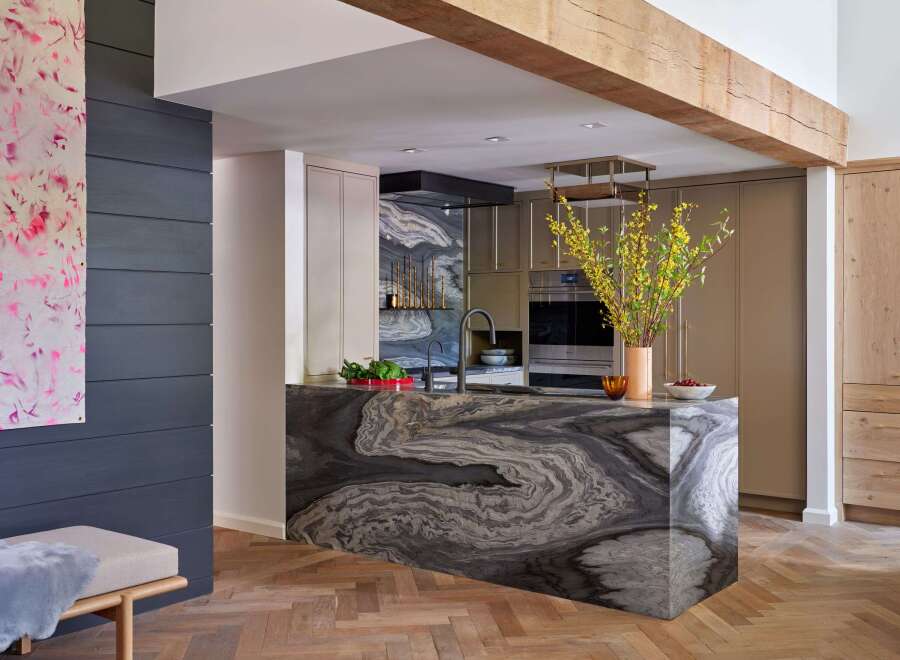 Experience luxury in this modern kitchen featuring a stunning marble island with intricate veining, complemented by sleek cabinetry and a sophisticated backsplash.