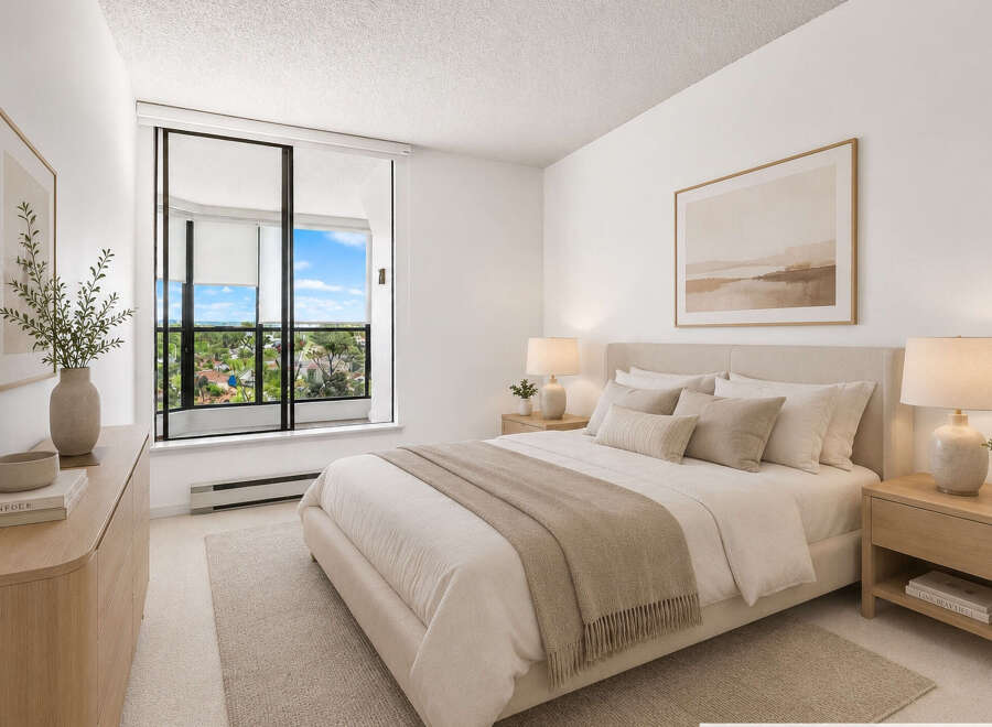Experience serene living in this beautifully appointed bedroom, featuring a plush king-sized bed adorned with neutral-toned linens and decorative pillows.