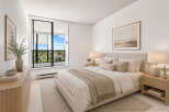 Experience serene living in this beautifully appointed bedroom, featuring a plush king-sized bed adorned with neutral-toned linens and decorative pillows.