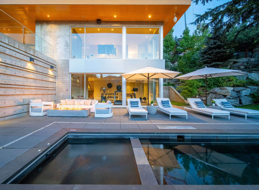 Experience luxury outdoor living with this stunning patio featuring a modern fire pit and comfortable lounge seating.