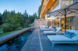 Experience luxury outdoor living with this stunning property featuring a sleek infinity pool and ample lounge seating.