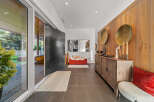Step into a modern entryway featuring a striking oversized pivot door and sleek tile flooring.