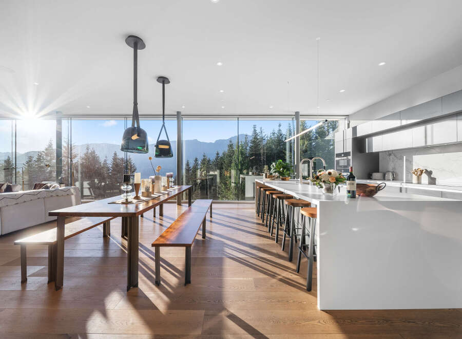 Experience breathtaking mountain views from this modern open-concept living space, featuring a gourmet kitchen with a large island and ample seating.