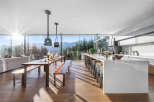 Experience breathtaking mountain views from this modern open-concept living space, featuring a gourmet kitchen with a large island and ample seating.