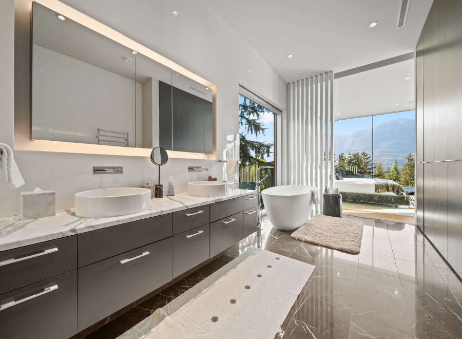 Experience luxury in this stunning master bathroom featuring a freestanding soaking tub with breathtaking mountain views.