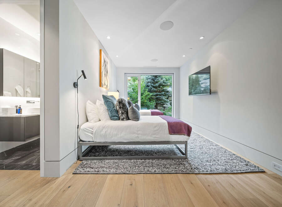 Experience modern luxury in this beautifully appointed bedroom featuring two comfortable beds, perfect for guests or family.