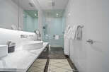 Experience modern luxury in this stunning bathroom featuring a sleek vessel sink atop a marble vanity.