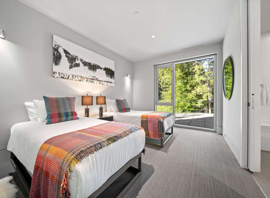 This inviting bedroom features two twin beds adorned with colorful, patterned throws and accent pillows, perfect for a cozy retreat.