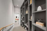 This modern hallway features a sleek gray built-in shelving unit, perfect for displaying decorative items.