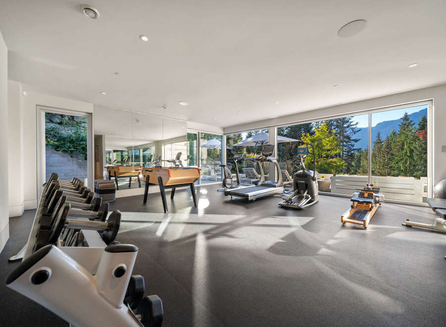 Experience ultimate wellness in this state-of-the-art home gym, boasting panoramic mountain views through expansive windows.