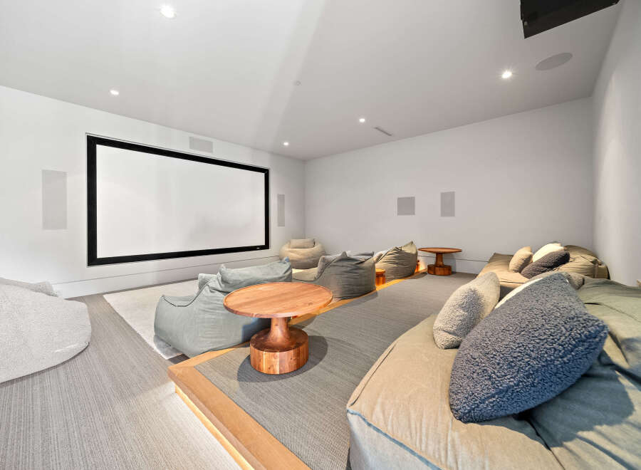 Experience ultimate relaxation in this modern home theater, featuring a large projection screen and comfortable beanbag seating.