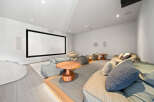 Experience ultimate relaxation in this modern home theater, featuring a large projection screen and comfortable beanbag seating.