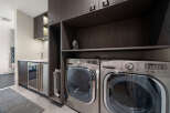 Discover modern convenience in this laundry room, featuring a sleek dark wood cabinetry system.