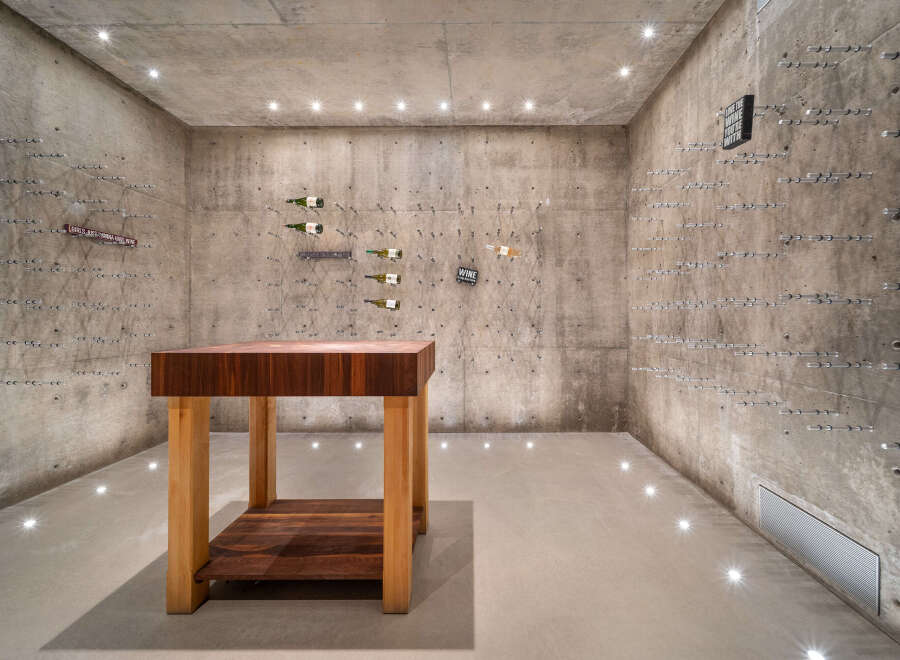 Discover a unique wine cellar featuring raw concrete walls and a minimalist aesthetic, perfect for the discerning collector.
